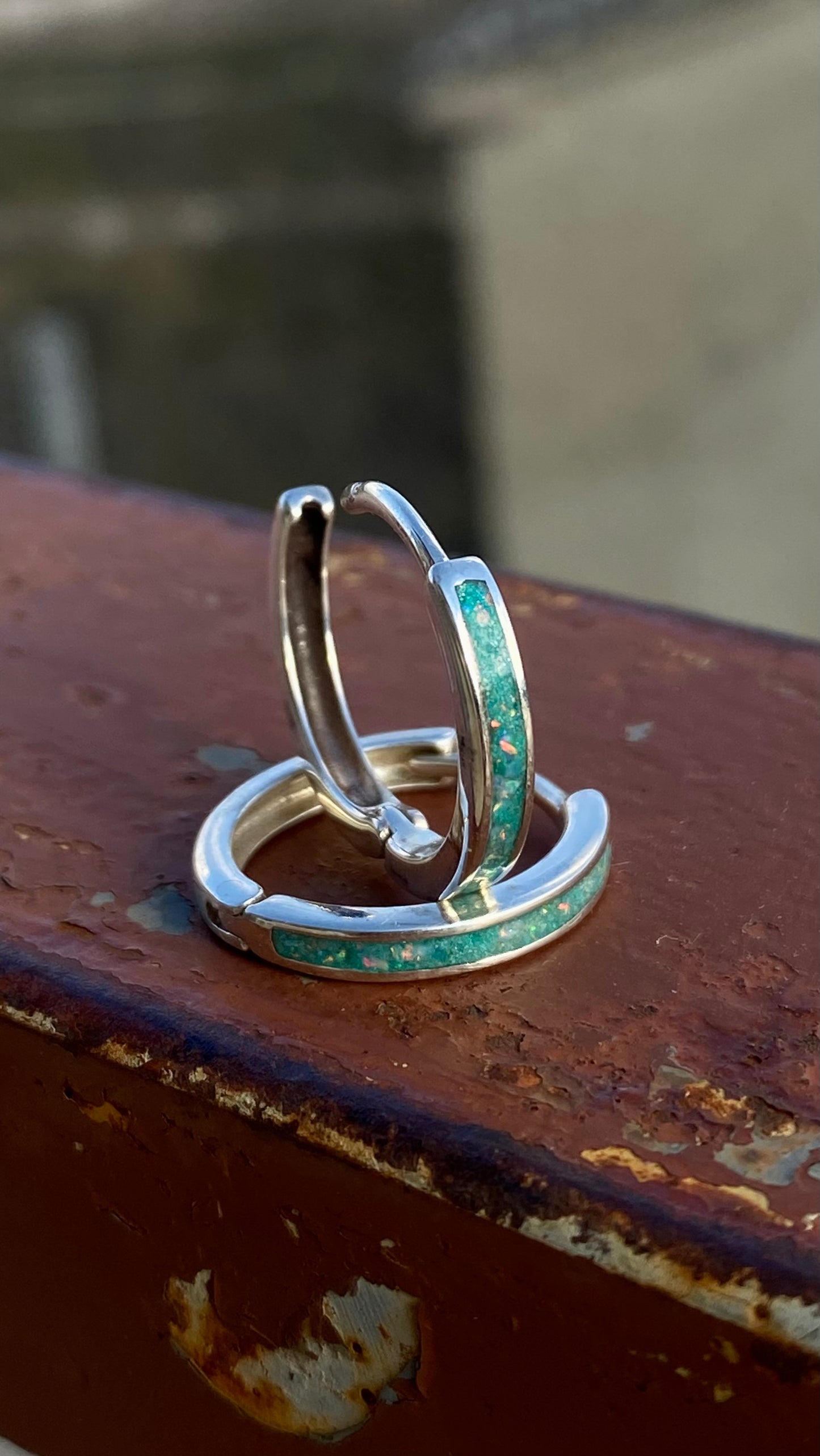 Opal earrings on aqua green background